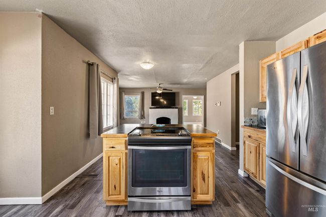 Kitchen featuring appliances with stainless steel finishes, a textured ceiling, a textured wall, dark wood-type flooring, and a ceiling fan | Image 14
