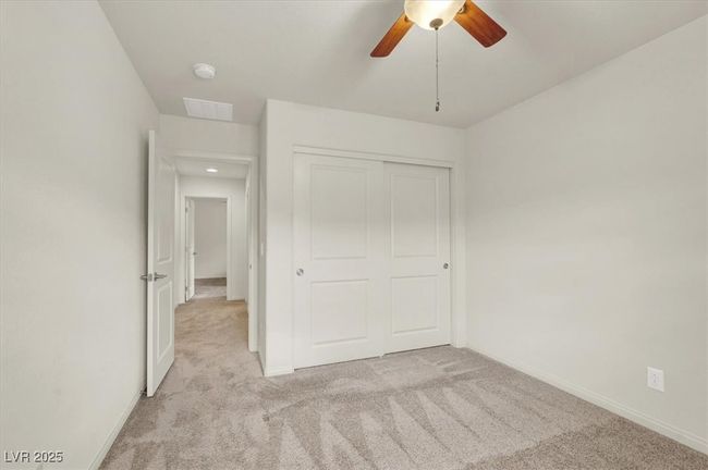 Unfurnished bedroom featuring light carpet, a closet, and ceiling fan | Image 49