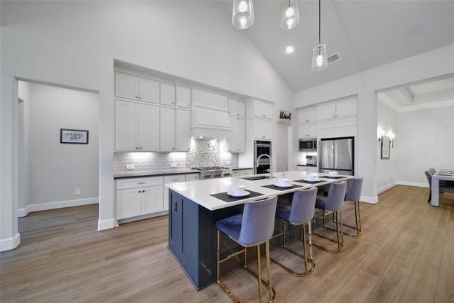 Oversized island with bar seating anchors the space, offering ample prep space and a central gathering spot. | Image 14