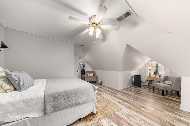 Bedroom featuring wood finished floors, vaulted ceiling, and a ceiling fan | Image 20
