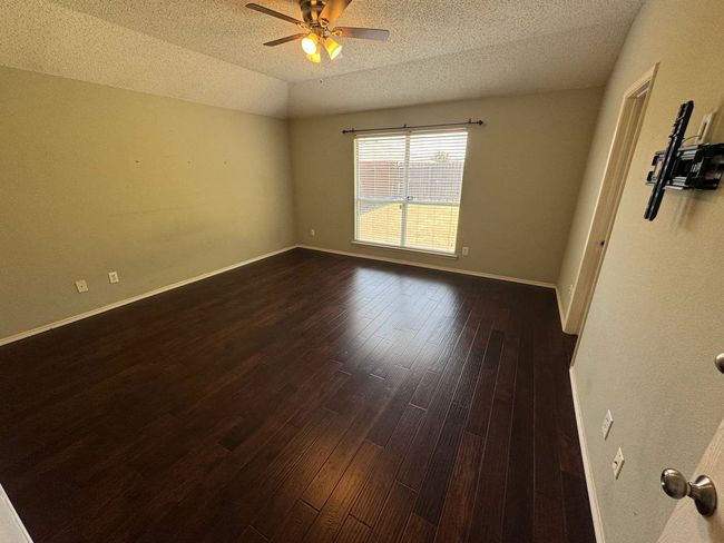 Spare room featuring dark wood-style flooring, a textured ceiling, vaulted ceiling, and ceiling fan | Image 7