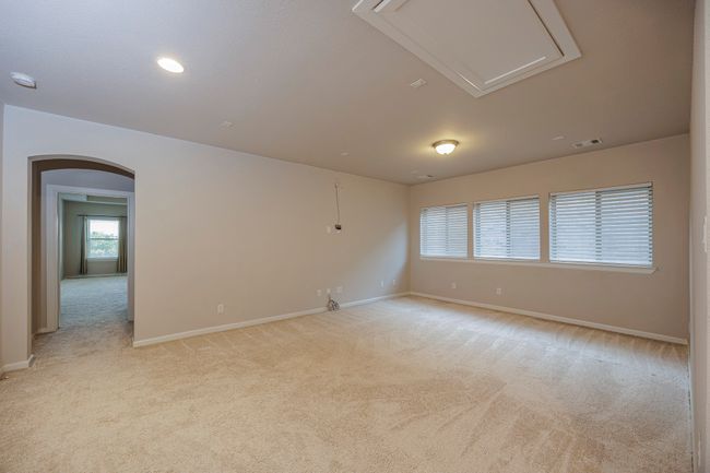 Unfurnished room with light carpet, arched walkways, attic access, and a smoke detector | Image 31