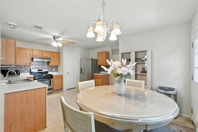 Dining space with a chandelier, ceiling fan, and light tile patterned floors | Image 11