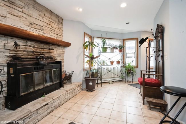 Sitting room featuring tile patterned flooring, a stone fireplace, and recessed lighting | Image 6