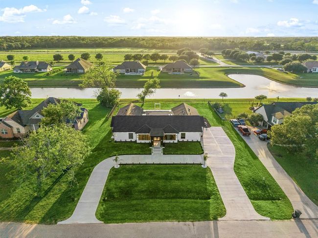 This elegant home is perfectly situated on a generous waterfront lot, featuring a long, private driveway and beautifully maintained landscaping. With serene water views and a peaceful neighborhood setting, this property offers both privacy and picturesque surroundings—ideal for relaxing and entertaining. | Image 43