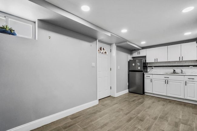 Kitchen with baseboards, a sink, light wood-style floors, and freestanding refrigerator | Image 15