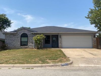 Ranch-style home with a garage and a front lawn | Image 1