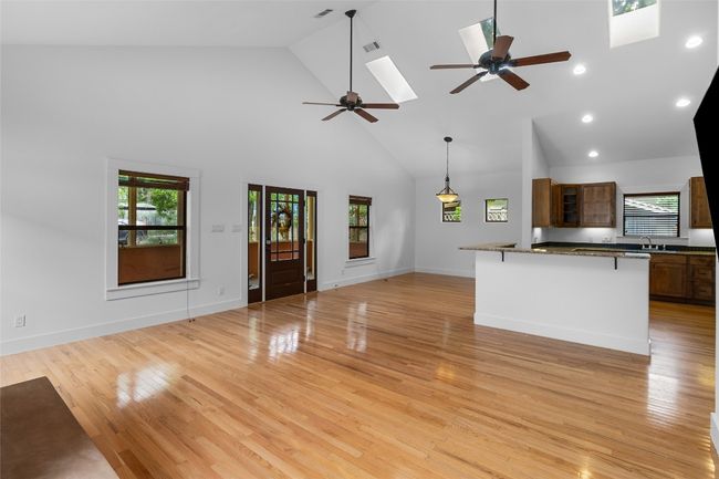Living room , dinning area and kitchen featuring high vaulted ceiling, plenty of natural light, a ceiling fan, and a skylight | Image 5