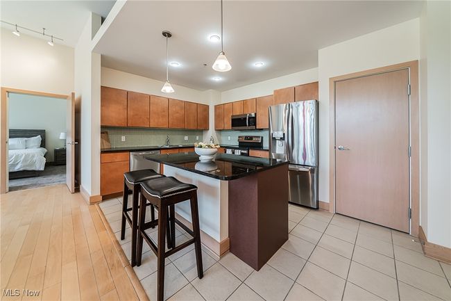 Kitchen with pendant lighting, stainless steel appliances, a center island, and pantry. | Image 15