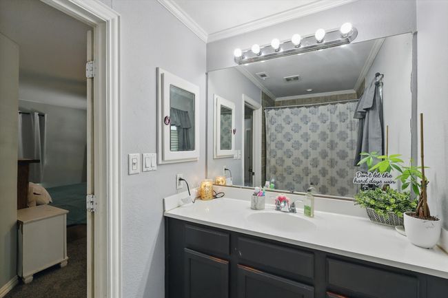 Full bathroom with vanity, ornamental molding, and a shower with shower curtain | Image 20