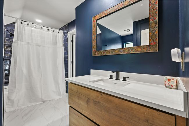 Bathroom featuring vanity and shower / bathtub combination with curtain | Image 28