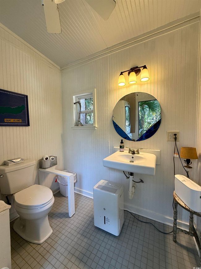 Half bath featuring a sink, toilet, tile patterned flooring, and baseboards | Image 35