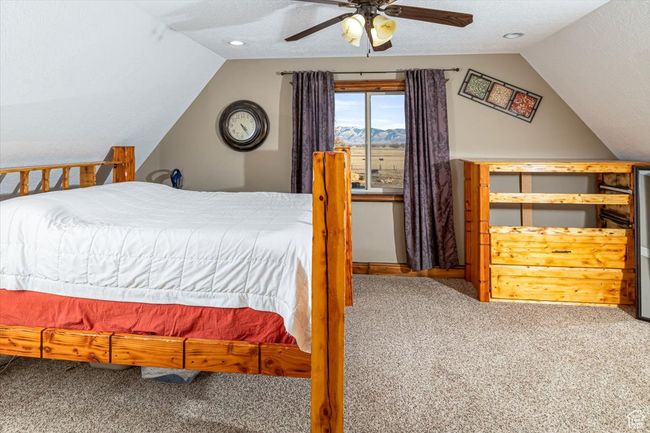 Bedroom with lofted ceiling, a textured ceiling, ceiling fan, and carpet | Image 17