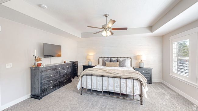 Bedroom with baseboards, ceiling fan, carpet flooring, and a raised ceiling | Image 17