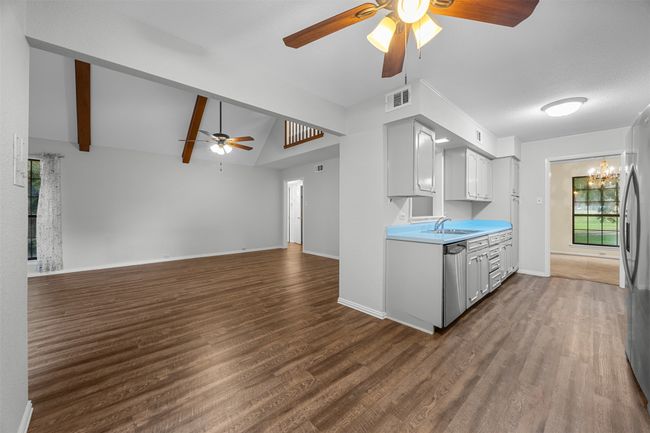Kitchen featuring a ceiling fan, a sink, appliances with stainless steel finishes, vaulted ceiling, and wood finished floors | Image 11