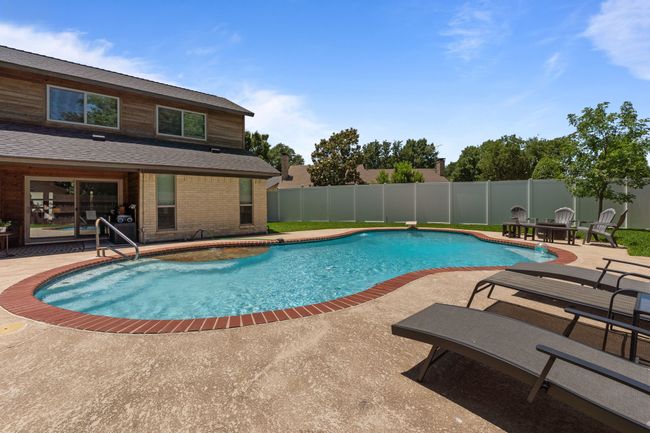 View of swimming pool with a patio and a fenced backyard | Image 32