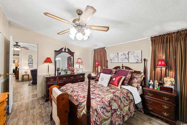 Bedroom featuring wood finished floors, a textured ceiling, and a ceiling fan | Image 6