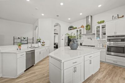 This kitchen is designed like a chef's triangle, offering seamless access to the sink, island, and stove with no obstructions. The layout is perfectly optimized for efficiency, allowing you to move effortlessly between these key areas while preparing meals. The modern island provides ample workspace, the sink is conveniently placed for quick cleanup, and the stove is ready for cooking—all within easy reach, creating a smooth, professional cooking experience | Image 1