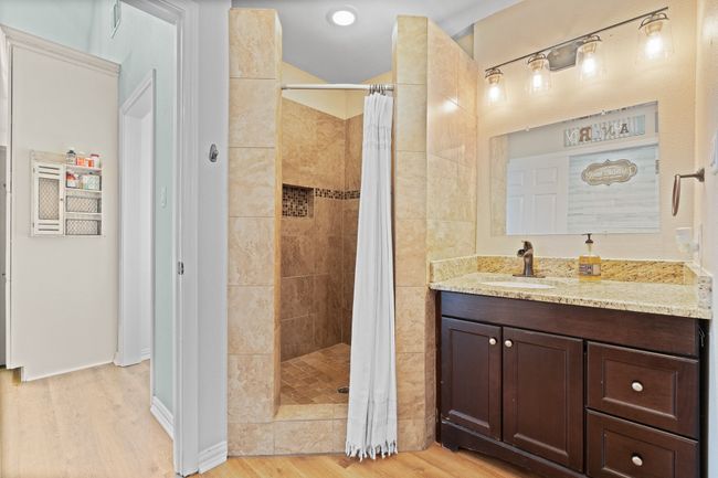 Bathroom with wood finished floors, tiled shower, and vanity | Image 15