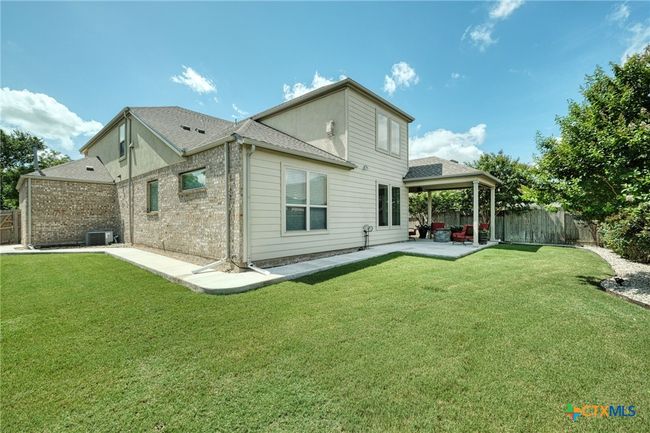 Back yard is private with wood fence enclosure and sprinklers. | Image 36