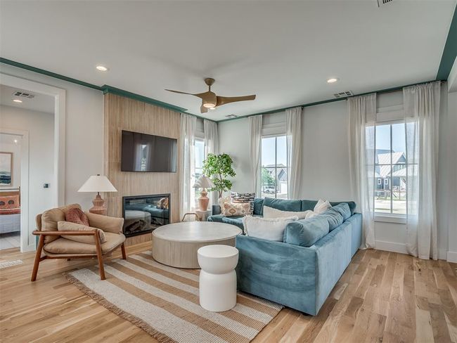 Living room featuring light wood-style flooring, a fireplace, ceiling fan, baseboards, and recessed lighting | Image 10