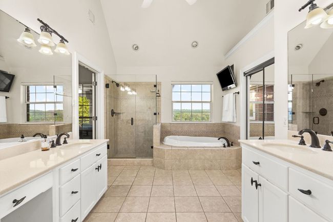 Another view of the primary bath showing the dressing table and view of the greenbelt. | Image 18