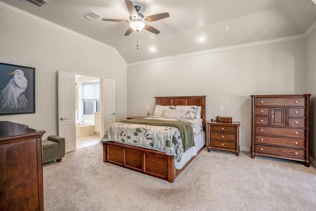 The primary bedroom has an spa like en-suite bathroom that is accessed through double doors. Notice the crown molding on the ceiling line. | Image 21