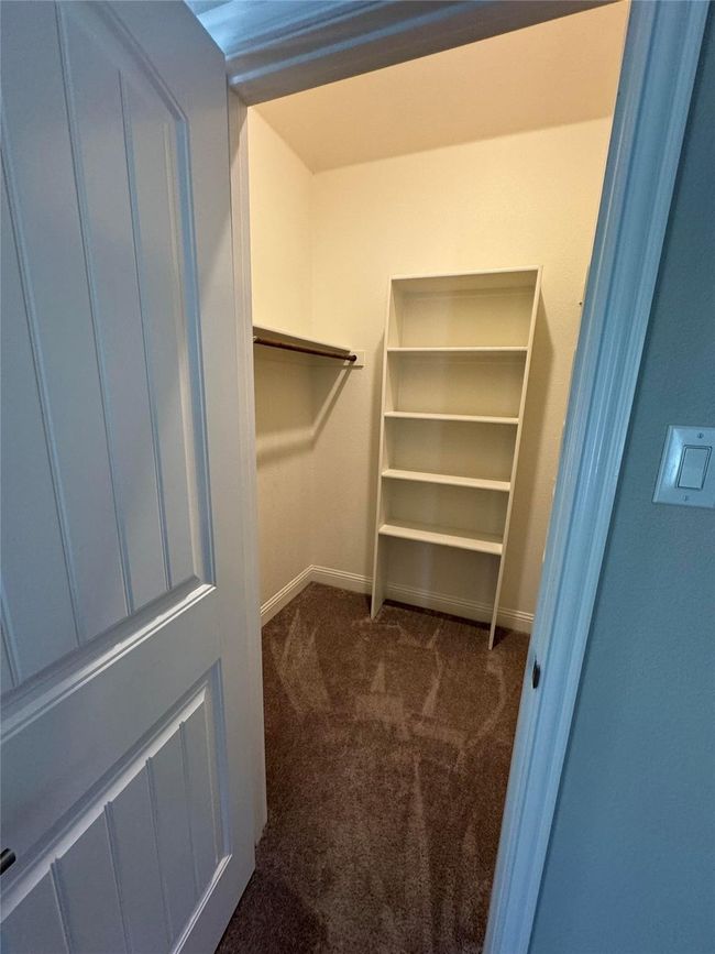 Spacious closet with dark carpet | Image 33