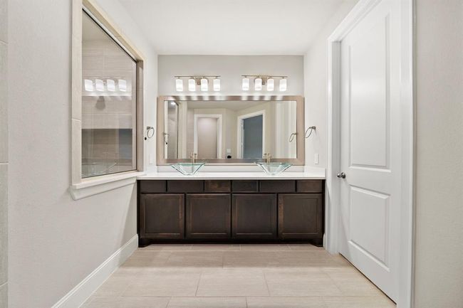 Another view of the vanity area featuring a framed mirro. | Image 16