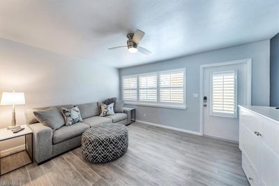 Living room with light hardwood / wood-style floors and ceiling fan | Image 3