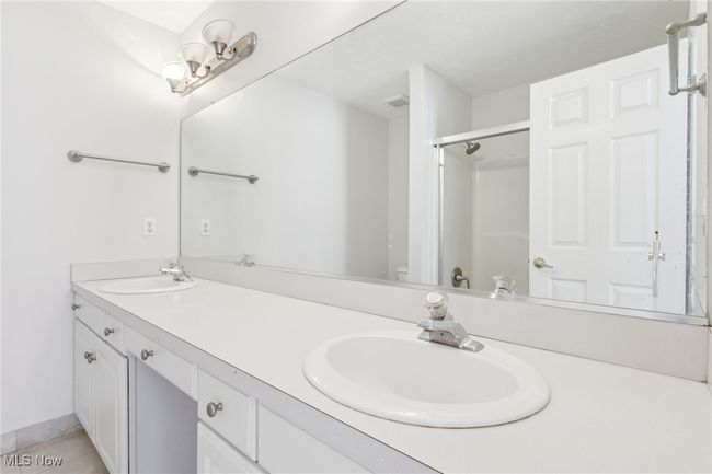 Full bathroom with tile patterned flooring, a sink, double vanity, and a stall shower | Image 19