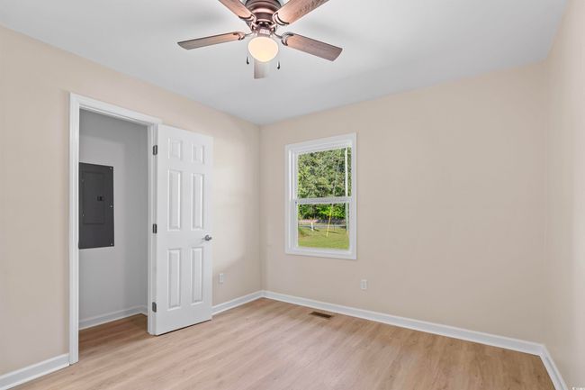Unfurnished room featuring electric panel, light wood-style floors, and ceiling fan | Image 24