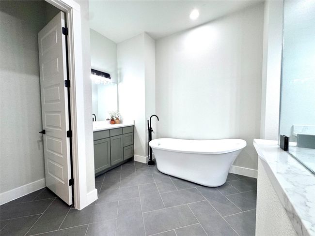 Bathroom featuring vanity, a soaking tub, tile patterned flooring, and recessed lighting | Image 22