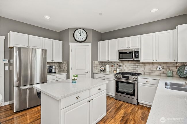 Kitchen boasts stainless steel appliances and quartz counter tops | Image 12