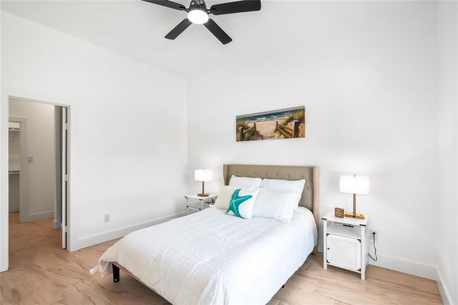 Spacious secondary bedroom with ample natural light and a walk-in closet, perfect for guests or a home office. | Image 15