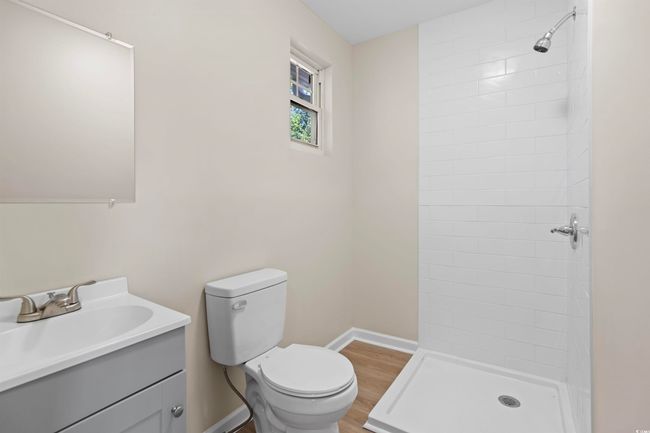 Bathroom featuring vanity, a tile shower, and wood finished floors | Image 36