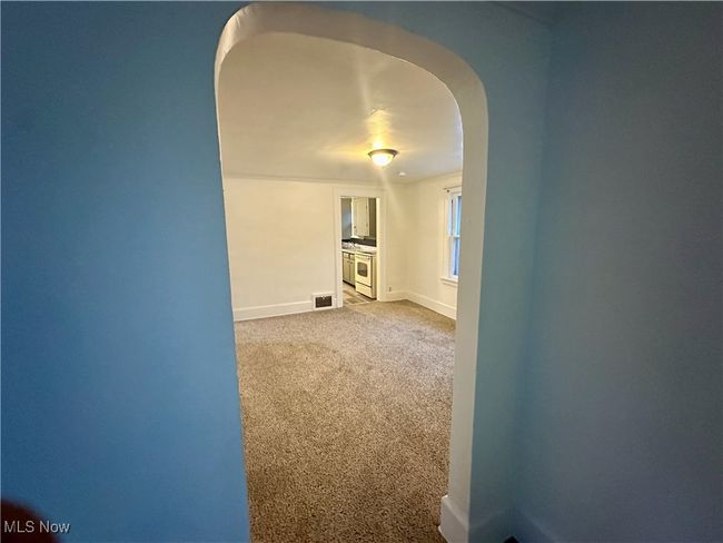 Unfurnished room featuring carpet, arched walkways, and baseboards | Image 11
