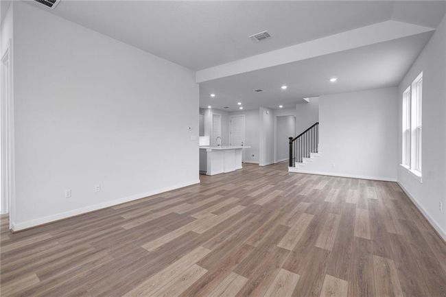 Unfurnished living room featuring wood finished floors, stairs, baseboards, and recessed lighting | Image 5