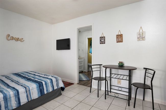 Bedroom featuring baseboards and light tile patterned floors | Image 7