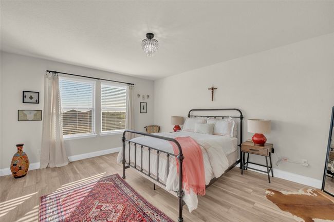 Bedroom with light wood-style flooring, baseboards and chandelier | Image 16