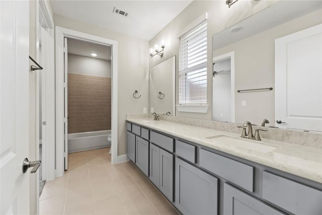 This full bathroom is easily shared between the two guest suites and features an extended dual-sink vanity with ample storage, stylish fixtures, and a separate tub/shower area for added comfort and privacy. | Image 25