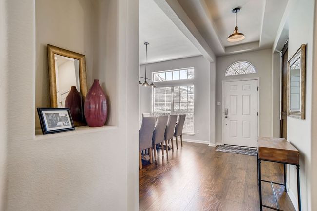 Foyer featuring wood finished floors, a chandelier, and a tray ceiling | Image 4
