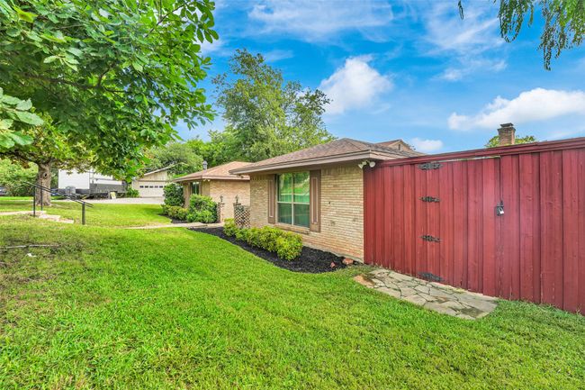 View of property exterior featuring brick siding, a yard, a garage, and a shingled roof | Image 4