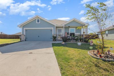 View of front facade with a garage and a front yard | Image 1