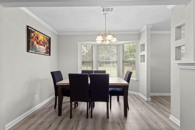 Dining room featuring an inviting chandelier, ornamental molding, baseboards, and light wood-type flooring | Image 10