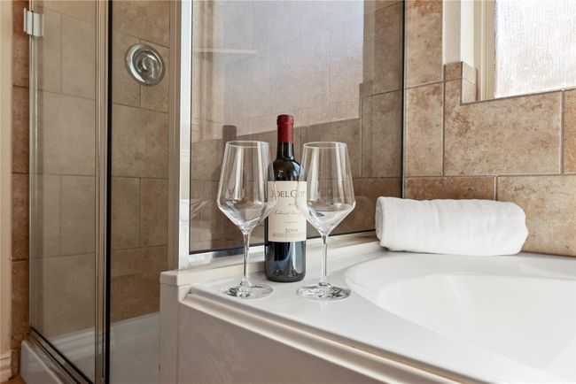 Come home to a glass of wine and a hot aromatherapy bubble bath in your enormous soaking tub. Afterward, easily rinse off the extra bubbles in the separate and spa-like glass enclosed shower. | Image 15