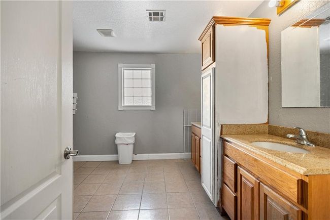 Bathroom featuring tile patterned flooring, vanity, and a textured ceiling | Image 33