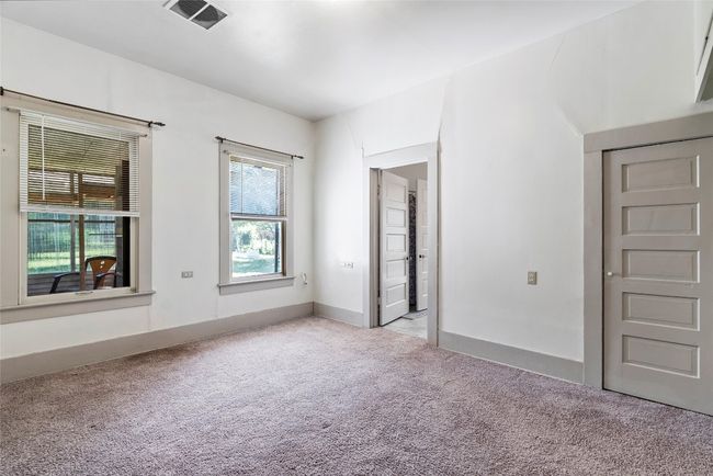 A spacious primary bedroom includes plush carpeting and a full en-suite bathroom | Image 14