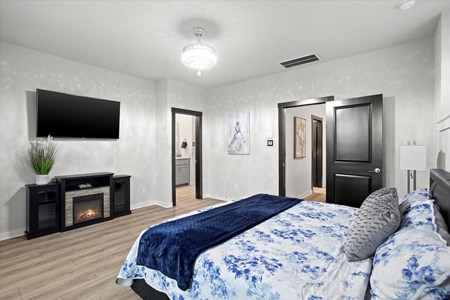 Bedroom featuring light wood-type flooring and a glass covered fireplace | Image 14