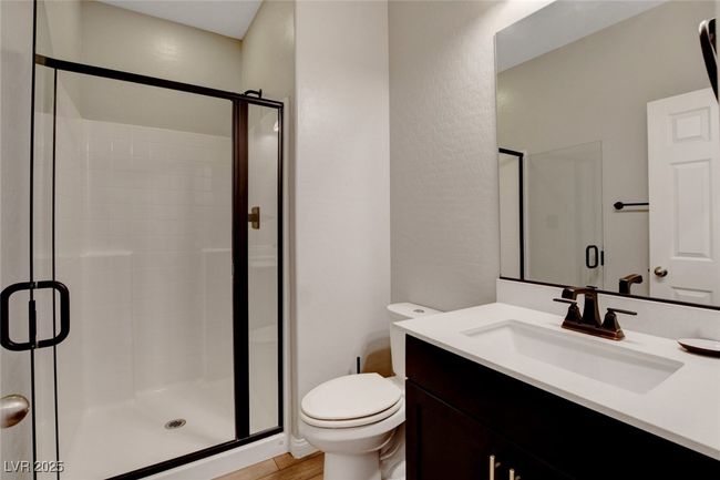 Bathroom with a shower stall, toilet, vanity, and wood finished floors | Image 10